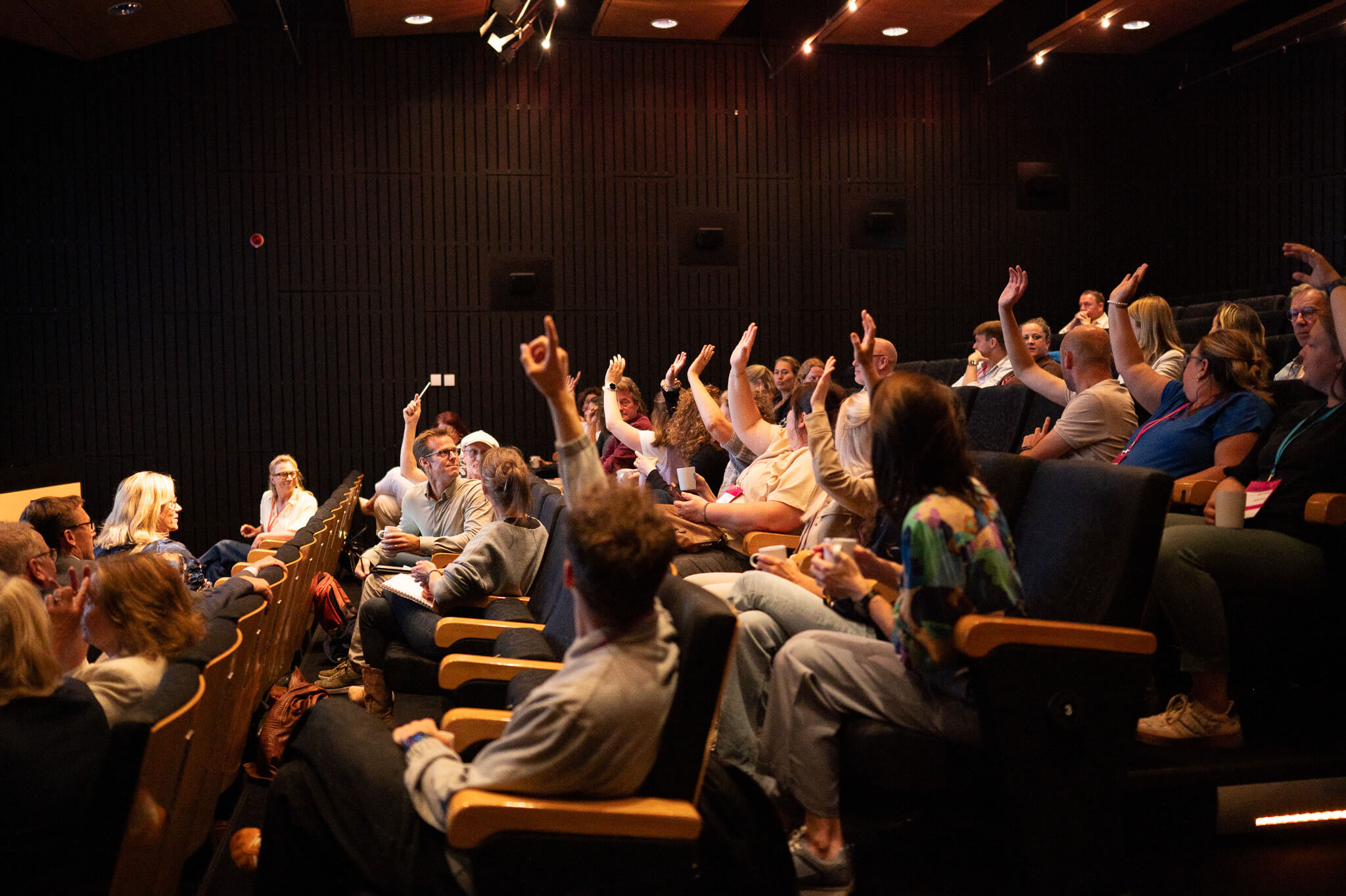 Mensen in een auditorium tijdens een vergadering of conferentie.